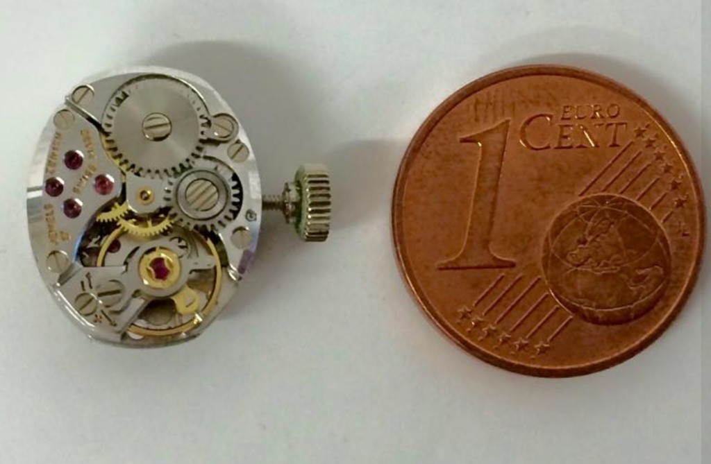 Mechanisches Uhrwerk neben einer 1-Cent-Münze als Maßstab
